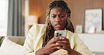 Confused, typing and black woman with phone in home for texting, networking or communication on app. Social media, bad news and female person with tech for fake website, scam or chat in living room