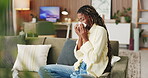 Sick, sneeze and black woman with tissue on sofa, flu season or chronic sinusitis for health crisis. Blowing nose, allergies or person with illness in home for recovery, hay fever or viral infection