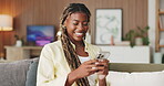 Laugh, typing and black woman on couch with phone, online communication and comic post on social media. Happy, digital and person in home with tech, funny text message or meme reaction on chat app.