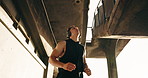 Stretching, health and headphones with man at beach for workout start, fitness radio and streaming. Warm up, training podcast and low angle with person outdoor for runner, wellness and challenge