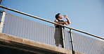Outdoor, drinking water and man with fitness, low angle and view with challenge, aqua or hydration. Rest, person or athlete with liquid, electrolytes or break for training, health benefits or thirsty