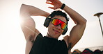 Stretching, sunglasses and headphones with man at beach for workout start, health radio and streaming. Warm up, training podcast and low angle with person outdoor for runner, wellness and challenge