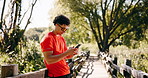 Fitness, smartphone and happy man with earphones at park, athlete and texting with contact on break. Outdoor, music and person with mobile for message, streaming and smile after exercise in nature