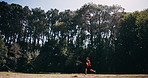 Running, athlete and man in nature for exercise, cardio and training routine for wellness or fitness. Outdoor, runner and person with endurance for workout, healthy and physical activity at park