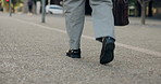 Person, walking and legs with bag in city for busines trip, work commute or outdoor travel. Employee, tourist or shoes moving with luggage for career journey or job opportunity in an urban town