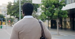 Businessman, walking and travel with bag in city for work trip, commute or outdoor journey. Back view, man or employee moving with luggage for career immigration or job opportunity in an ubran town