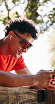Happy man, fitness or listening with earphones or phone in nature for music or outdoor workout break. Active, male person or smile with mobile smartphone or earpods for audio streaming or sound app