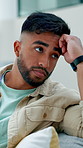 Upset, man or thinking with stress on sofa for bad news, regret or disappointment in home. Thoughtful, concern or male person with depression, anxiety or doubt for mistake, poor decision or rejection