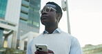 Serious, businessman and thinking with phone in city, travel and searching for directions on website. Employee, reflection and black person with digital map, low angle and commute with mobile on road