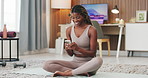 Black woman, phone and texting with exercise in home on yoga mat, break and happy with funny post on web. African person, smartphone and rest for fitness on floor, mobile app or social media at house