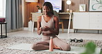 Phone, pilates or woman drinking water in home for exercise break, liquid hydration or notifications. Fitness, mobile and black girl with beverage on mat for workout thirst, electrolytes and texting