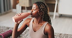 Black woman, drinking water and rest for exercise in home on floor, thinking and break with hydration. African person, bottle and reflection with fitness, wellness or smile with electrolytes in house