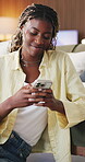 Black woman, phone and happy with typing on sofa in home for communication, internet and online dating. Female person, technology and connection to browse on social media app in living room on couch