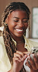 Typing, smile and black woman with phone in house, message response and social media caption for thinking. Texting, reflection and person with mobile for online communication, laugh and internet joke