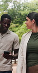 Man, woman and phone at park on business trip with talk, share post or notification on commute. People, travel and discussion with mobile app, coffee and partner with smile for social media in summer
