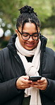 Phone, typing and woman in woods, smile and digital app for social media, internet and subscription. Outdoor, reading or person in forest, tech for communication or website info for wellness tracker