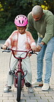 Outdoor, father and girl with bicycle for teaching, support and guidance for coordination development. Park, learning balance and man with child for cycling practice, improve motor skills and bonding