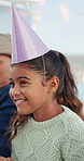 Happy, birthday and child at party with hat for celebration, social gathering and special day outdoor. Family, laugh and girl with decorations, balloons and streamers for eating cake, snacks and food