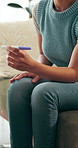 Stress, pregnancy test and woman on sofa in home with regret, upset or mistake for unplanned maternity. Anxiety, scared and female person with positive result for failed birth control in house.