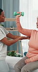 Physiotherapist, dumbbells and old woman in office, consultation for recovery and wellness. People, physical therapist and patient in clinic, help and support for healing, fitness and medical service