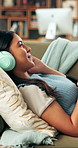 Woman, headphones and relax with phone on sofa for streaming service, pillow and smile in home. Girl, smartphone and listen to music with audio, sound and chill with subscription on couch at house