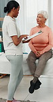 Elderly, woman and physiotherapist in clinic with clipboard, discussion and feedback for rehabilitation. Senior person, healthcare worker and talk with checklist, physical therapy and medical report.