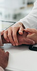 Doctor, holding hands and empathy with old person in office for terminal diagnosis, support and healthcare. Medical, help and comfort with senior patient in clinic for advice, trust and cancer news