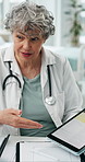 Hospital, talking and mature doctor on tablet for consulting, advice and research for treatment. Healthcare, screen and woman on tech for medical service, website and report for patient diagnosis
