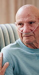 Old man, talk and tube for oxygen in home with breathing aid, discussion and recovery in retirement. Elderly person, chat and cannula for rehabilitation, healing and conversation on couch at house