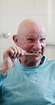 Senior man, toothbrush and brushing teeth in home for hygiene, fresh breath and oral care. Bathroom, toothpaste and elderly person with disability, cleaning mouth and morning routine at house