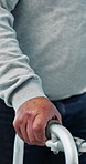 Senior, person and hands with walker for mobility, physiotherapy or muscle recovery in hospital. Elderly, patient and walking with aid, support or help for stability, balance or control in clinic