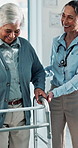 Discussion, physiotherapist and old woman with walker in clinic, mobility assistance and balance help. Rehabilitation, specialist and senior patient with medical support for recovery, smile and talk