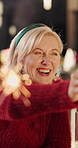 Christmas, sparkler or woman with smile in dining room, holiday celebration party or family bonding. Firework, happiness or people with reunion for festive season, December tradition or event in home
