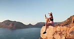 Woman, hiking and smartphone for photo on mountain top with ocean view, space or relax in summer. Girl, phone and post on break, rocks or profile picture for trekking, app and social media on cliff