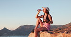 Woman, hiking and drinking water with rest on mountain for ocean view, space and relax on rocks. Girl, outdoor and bottle for hydration, break and wellness with trekking, adventure or tired in summer