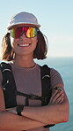 Arms crossed, face and woman on hiking break to relax, rest and smile by ocean with confidence. Person, fitness and trekking outdoor with gear, sunglasses and happy for exercise and wellness