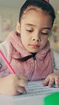 Writing, learning and child in classroom at school with education for test, assignment or quiz. Scholarship, growth and girl student with activity for development, studying or knowledge in lesson.