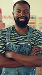Face, confidence and black man in cafe, barista and smile with professional for career pride. Portrait, arms crossed and happy waiter in coffee shop, customer service and hospitality industry