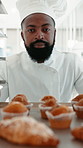 Black man, face and tray with muffins at bakery with smile, pride and confidence at confectionery store. Person, chef and baker in portrait with cake, happy and trolley for dessert at restaurant