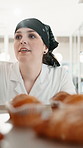 Woman, chef and tray with muffins in kitchen with walk, cooking and thinking at confectionery store. Person, pastry and cake at bakery with order, process or cuisine with dessert at restaurant