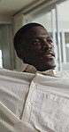 Thinking, relax and black man on sofa in home with nostalgia, memory or planning for weekend. Smile, ideas and African male person with smile for reflection or decision in living room at apartment.