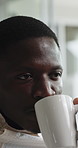 Coffee, relax and black man on sofa in home with thinking, nostalgia or memory on weekend. Reflection, drinking and African male person with warm beverage for planning in living room at apartment.