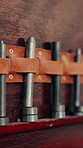 Leather, tools and hardware in workshop with wall, manufacturing service and metal for maintenance. Material belt, building equipment and gear in repair shop for industrial work, production or craft.
