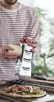 Hands, man and pizza with cheese at house for meal prep, ingredients and Italian recipe. Chef, cooking and grater with toppings for pastry flavor, healthy food and culinary skills for homemade lunch