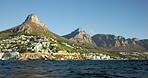 Landscape, mountain and buildings on island with sea, nature and coastal city for tourist destination. Outdoor, sustainable environment and town by ocean with peace, paradise and scenic for vacation.