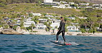 Ocean, fitness and woman on electric surfboard for active, workout or water sports on vacation. Travel, adventure and female person on efoil by sea for exercise, training or surfing on holiday.