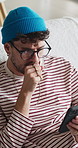 Tired, man and yawn with phone on sofa for fatigue, scrolling or insomnia with app in home. Exhausted, male person or user browsing with mobile smartphone for research, information or tips in house