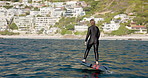 Ocean, back and woman on electric surfboard for active, workout or water sports on vacation. Travel, fitness and female person on efoil by sea for exercise, adventure or surf training on holiday.