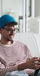 Happy, tablet and man on sofa in home with communication, social media or reading blog online. Digital technology, relax and male person in living room for texting on app for contact in apartment.