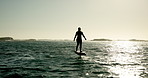 Ocean, sports and woman on electric surfboard for active, workout or fitness on vacation. Travel, adventure and female person on efoil by sea for exercise, training or surfing challenge on holiday.